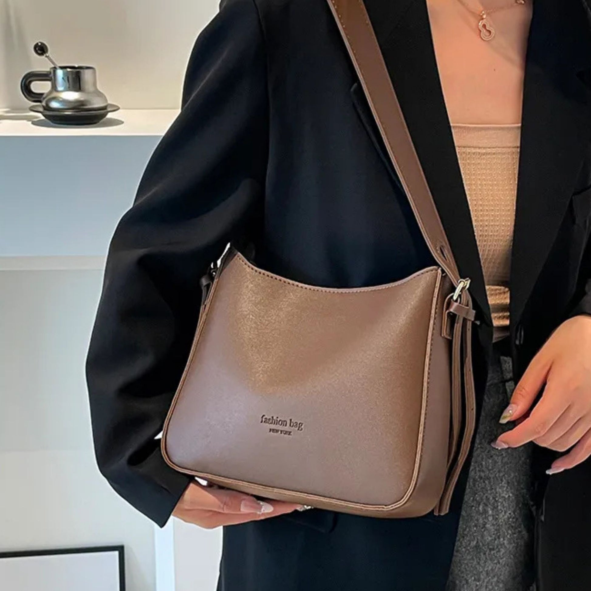 Person holding a brown shoulder bag