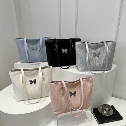Collection of totebags with butterfly designs on a white surface against a light gray background