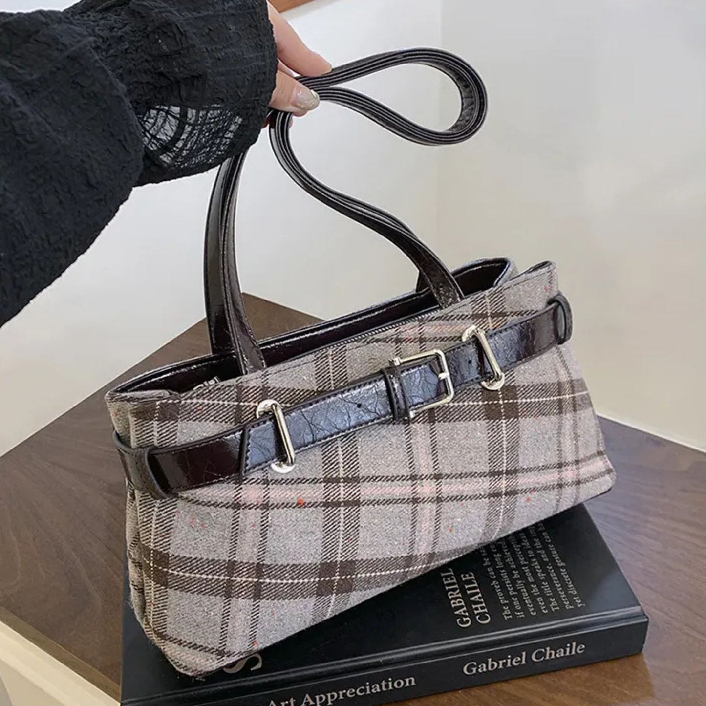 Plaid handbag held above a book