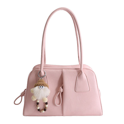 Pink handbag with a fluffy keychain on a white background