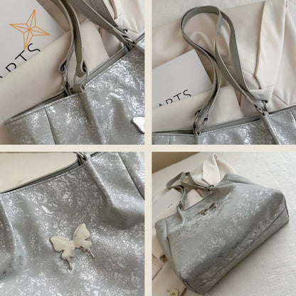 Silver glittery totebag with butterfly charm on a white background