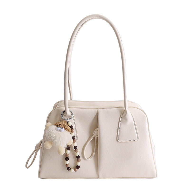 White handbag with a keychain on a white background