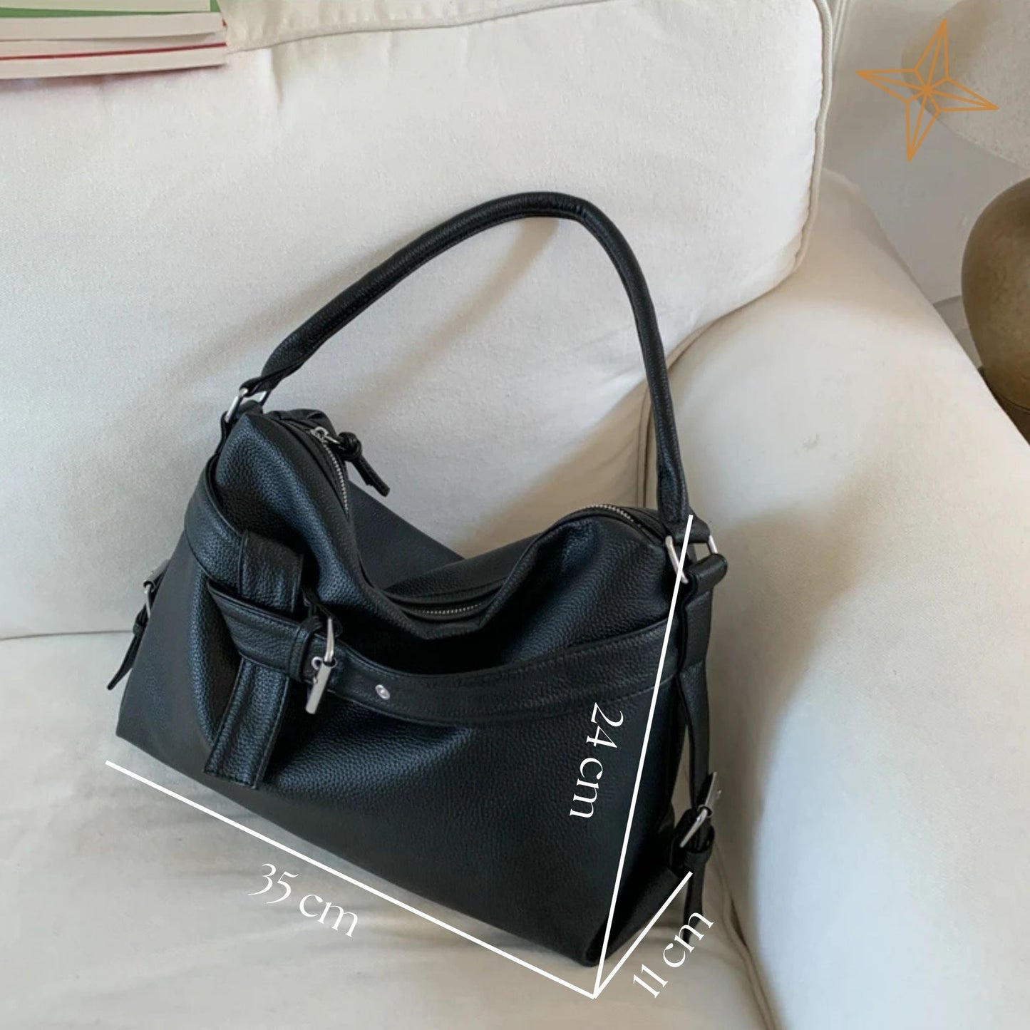 Black totebag on a light-colored sofa with measurements indicated